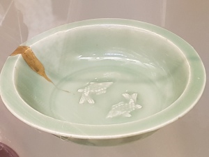 Japanese bowl decorated with two fish.  A crack in the bowl has been repaired with golden laquer.  
